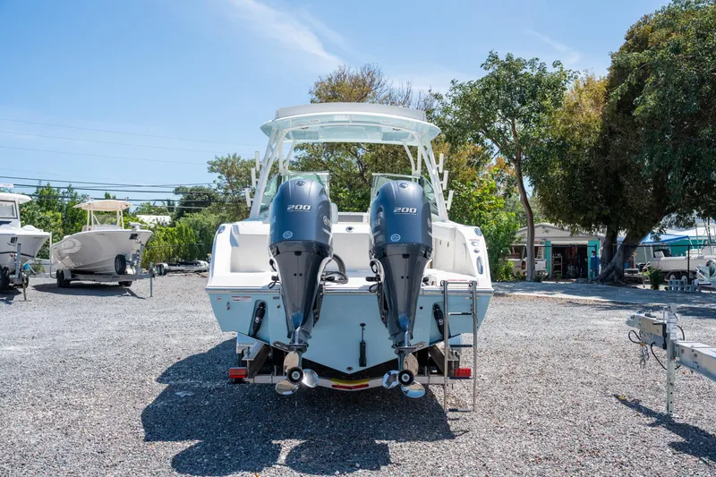 Slide: The Image of 2024 Cobia 280 DC boat with dual 200 horsepower engines, parked outdoors. - 6