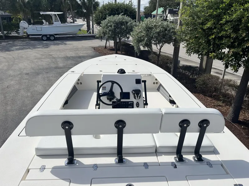 Slide: The Image of 2024 Hewes Redfisher 21 boat, white interior, parked outdoors near trees. - 11