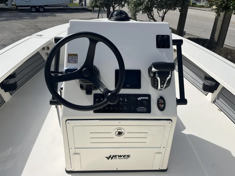 Slide: The Image of 2024 Hewes Redfisher 21 boat console with steering wheel and controls. - 12
