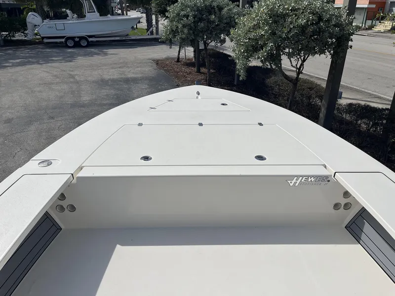 Slide: The Image of 2024 Hewes Redfisher 21 boat deck, parked outdoors, showcasing sleek design and spacious layout. - 13