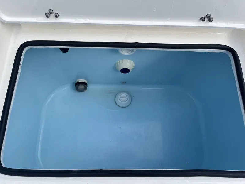 Slide: The Image of Livewell compartment of 2024 Hewes Redfisher 21 boat, featuring a clean blue interior. - 20