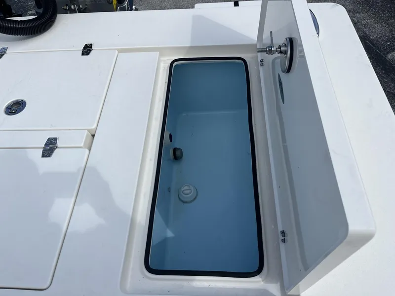 Slide: The Image of 2024 Hewes Redfisher 21 boat storage compartment with open lid, showcasing interior space. - 21