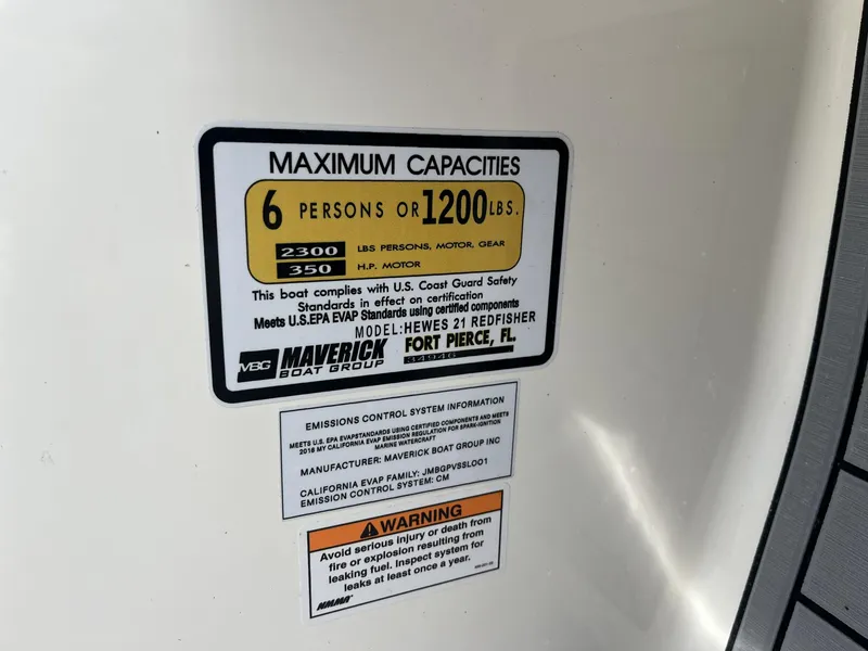 Slide: The Image of 2024 Hewes Redfisher 21 capacity label, maximum 6 persons or 1200 lbs, safety compliance. - 24