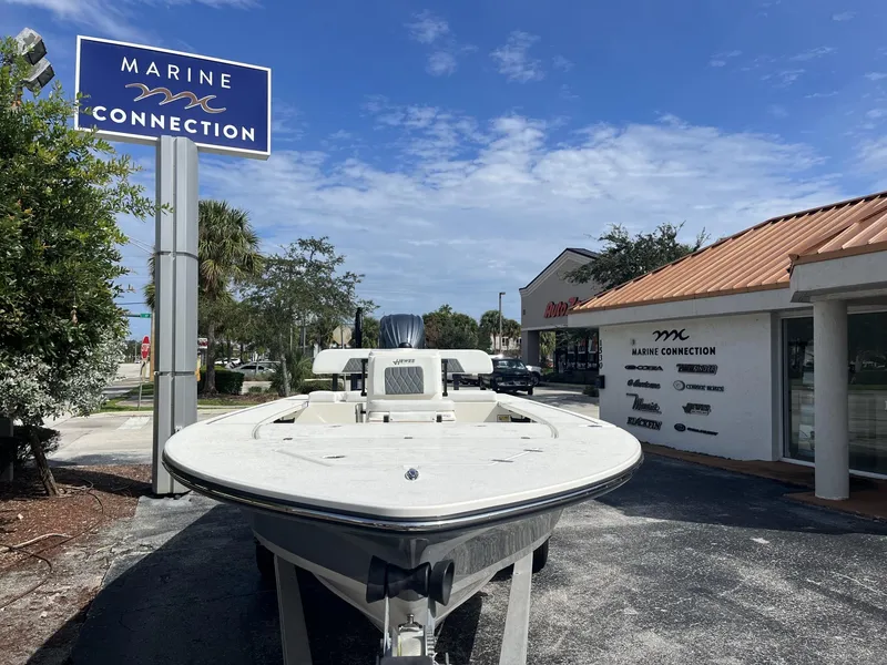 Slide: The Image of 2024 Hewes Redfisher 21 boat at Marine Connection dealership under a clear blue sky. - 3