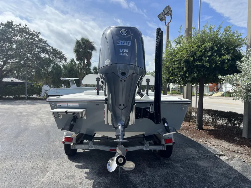 Slide: The Image of 2024 Hewes Redfisher 21 boat with powerful outboard motor, parked outdoors. - 5