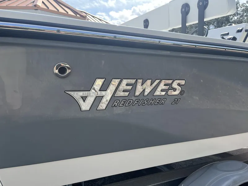 Slide: The Image of 2024 Hewes Redfisher 21 boat side view with logo and sleek design. - 7
