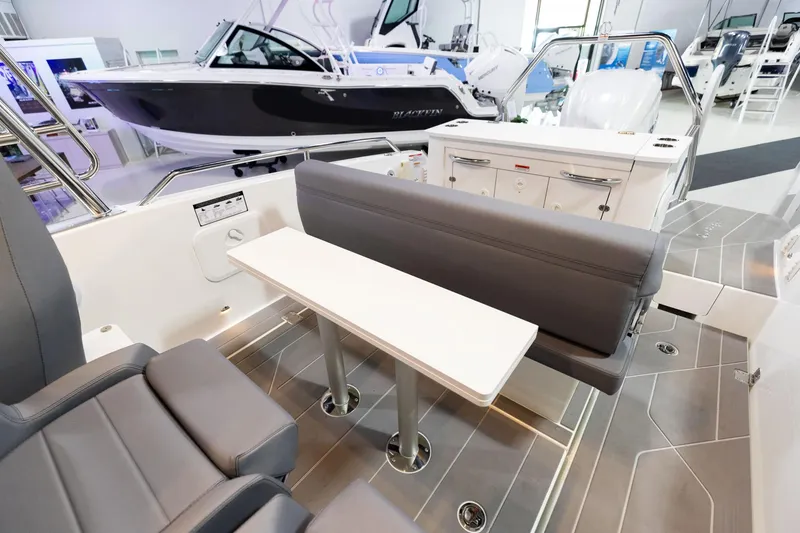 Slide: The Image of 2024 Quarken 27 T-Top V2 boat interior with seating and table in showroom. - 10