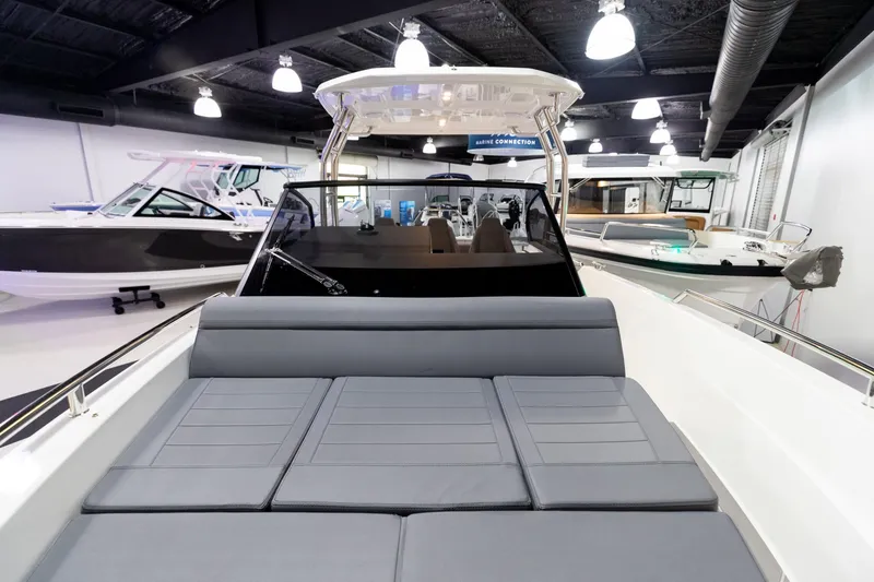 Slide: The Image of 2024 Quarken 27 T-Top V2 boat interior with cushioned seating in showroom. - 27
