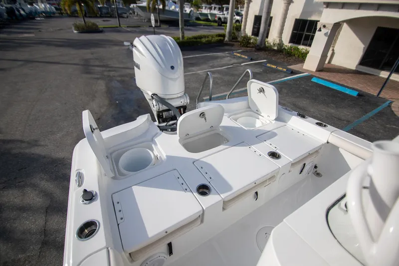 Slide: The Image of 2024 Sea Hunt BX 25 FS boat with open storage compartments and outboard motor. - 10