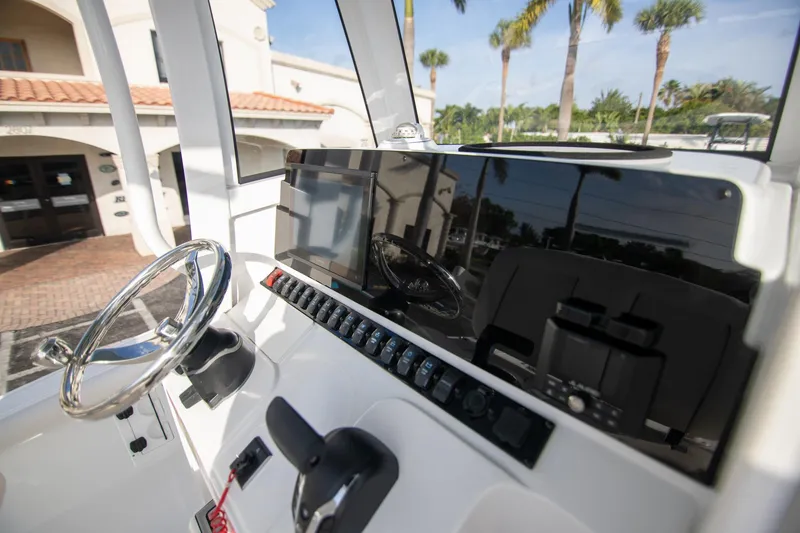 Slide: The Image of 2024 Sea Hunt BX 25 FS boat dashboard with steering wheel and control panel. - 16