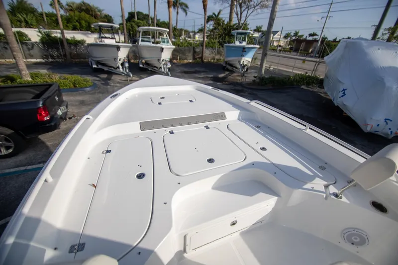 Slide: The Image of 2024 Sea Hunt BX 25 FS boat deck, parked with other boats and vehicles nearby. - 20