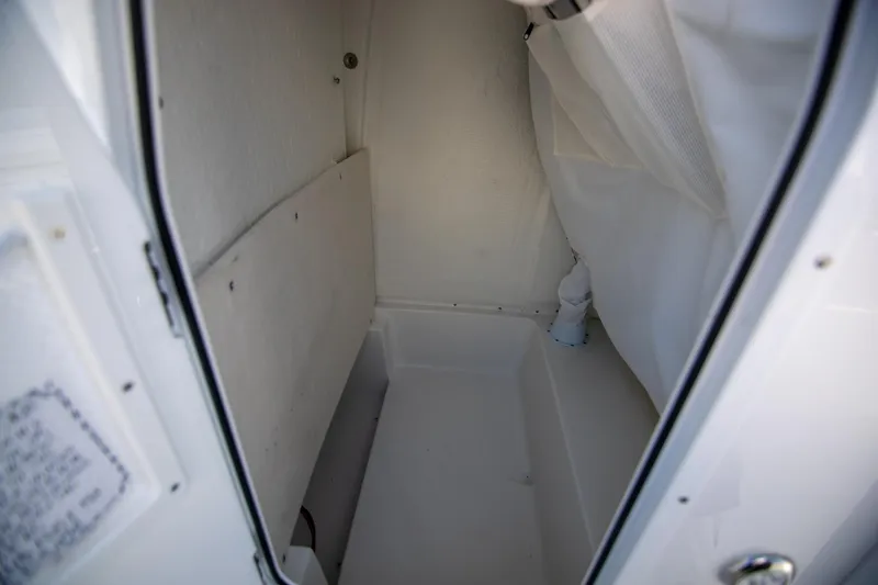 Slide: The Image of 2024 Sea Hunt BX 25 FS interior storage compartment, white and spacious design. - 26