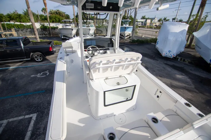 Slide: The Image of 2024 Sea Hunt BX 25 FS boat interior with console and seating, parked outdoors. - 6