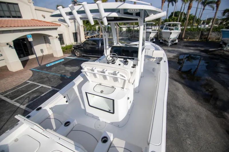 Slide: The Image of 2024 Sea Hunt BX 25 FS boat, white interior, parked outdoors near buildings and palm trees. - 8