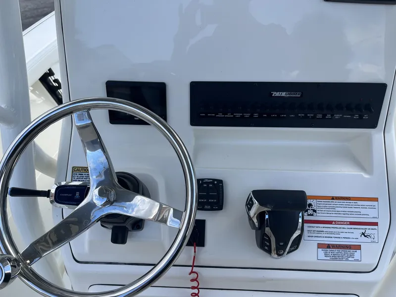 Slide: The Image of 2024 Pathfinder 2400 Open boat dashboard with steering wheel and controls. - 11
