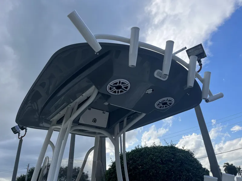 Slide: The Image of 2024 Pathfinder 2400 Open boat with rod holders and speakers under a cloudy sky. - 29