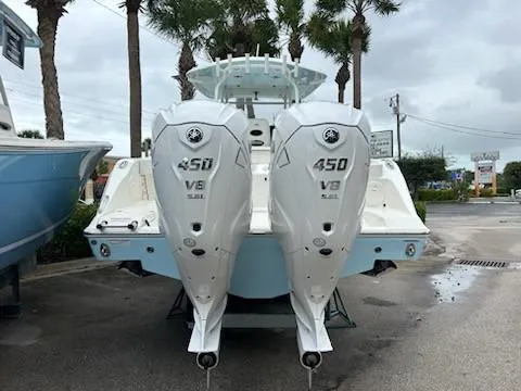 Slide: The Image of 2024 Cobia 350 CC boat with twin 450 V8 engines, parked outdoors. - 2