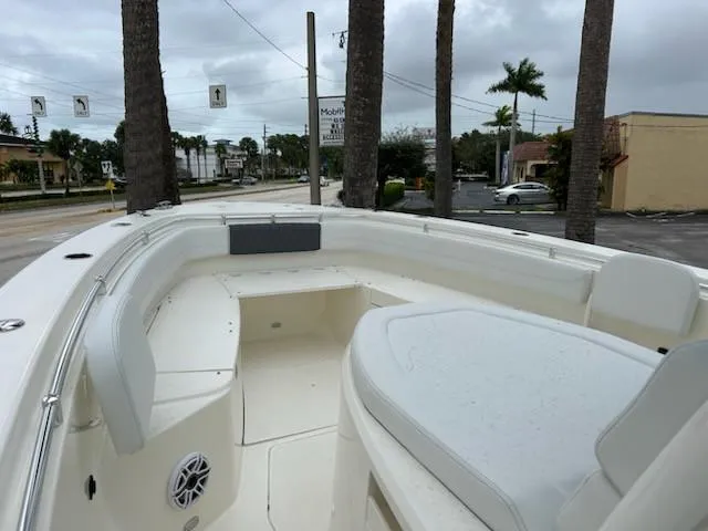 Slide: The Image of 2024 Cobia 350 CC boat interior with seating and speaker, parked near palm trees. - 6