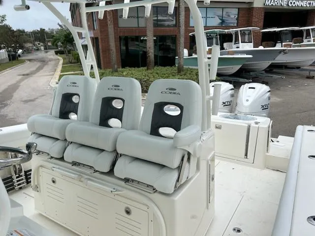 Slide: The Image of 2024 Cobia 350 CC boat interior with triple seating and outboard engines. - 5