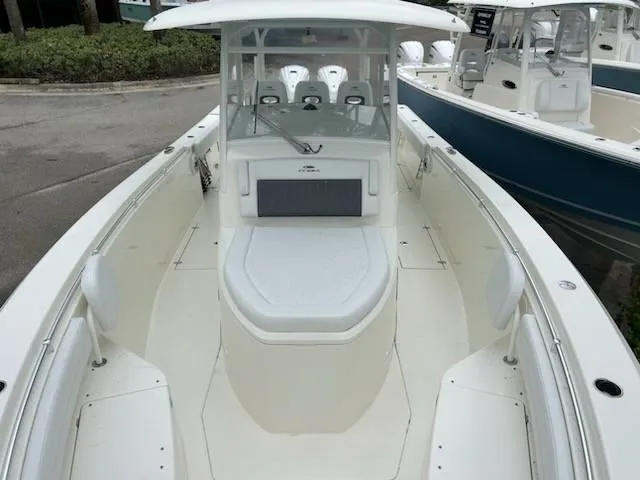 Slide: The Image of 2024 Cobia 350 CC boat, spacious deck, sleek design, white exterior, docked at marina. - 7