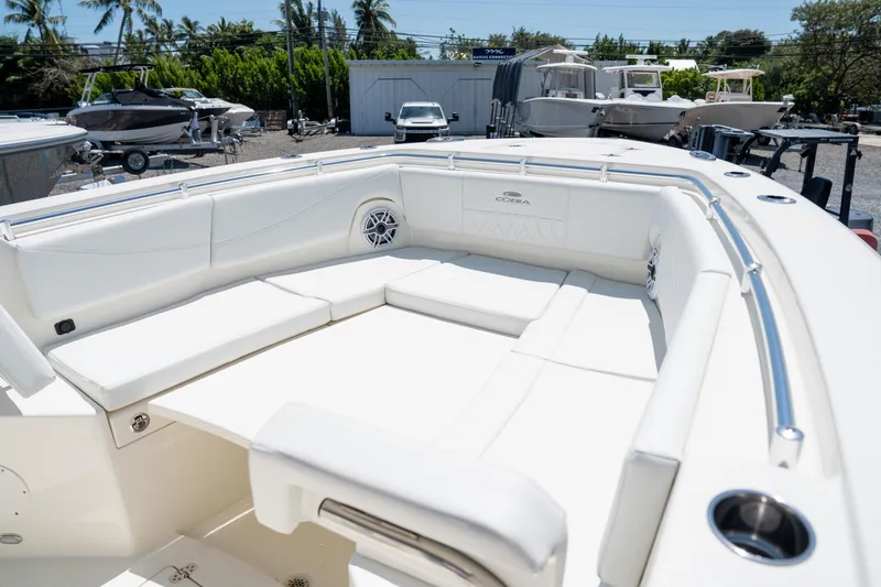 Slide: The Image of 2024 Cobia 320 CC boat with spacious white seating area and sleek design. - 39