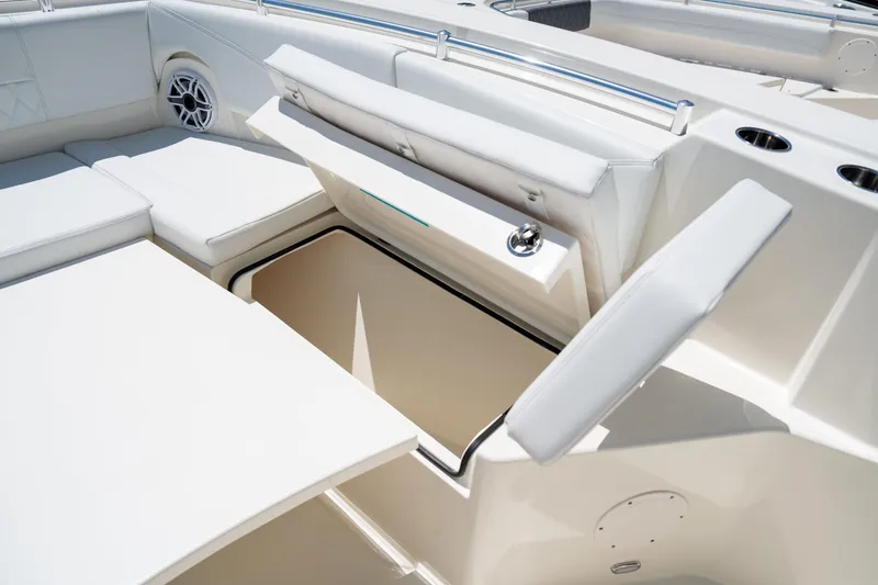 Slide: The Image of 2024 Cobia 320 CC boat interior with open storage compartment and cushioned seating. - 40