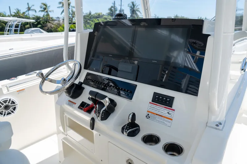 Slide: The Image of 2024 Cobia 320 CC boat dashboard with steering wheel and electronic controls. - 11