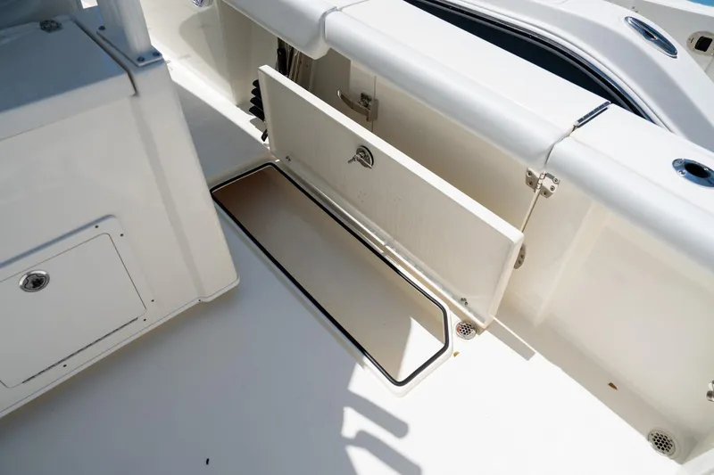 Slide: The Image of 2024 Cobia 320 CC boat storage compartment with open hatch, showcasing interior space. - 31