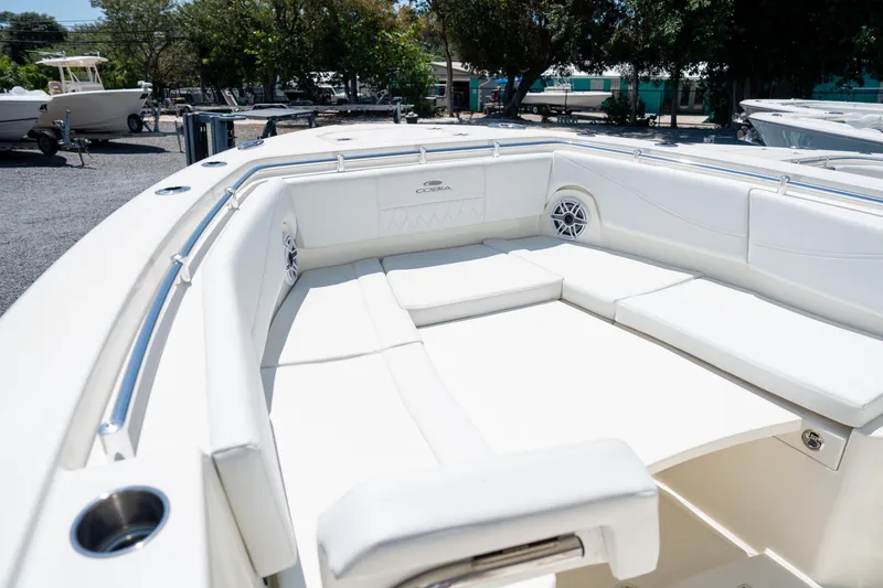 Slide: The Image of 2024 Cobia 320 CC boat interior with white cushioned seating and stainless steel accents. - 38