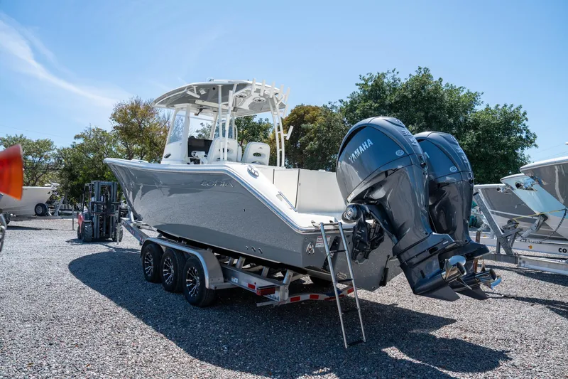 Slide: The Image of 2024 Cobia 320 CC boat with dual Yamaha engines on a trailer. - 6