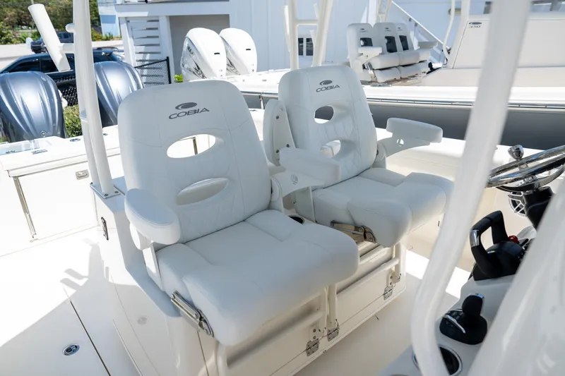 Slide: The Image of 2024 Cobia 320 CC boat with luxurious white captain's chairs and dual engines. - 15
