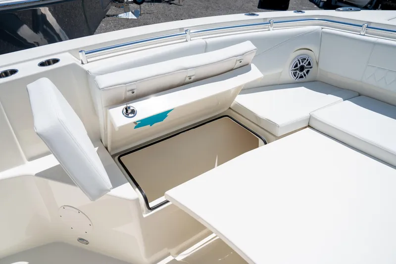 Slide: The Image of 2024 Cobia 320 CC boat interior with open storage compartment and cushioned seating. - 41