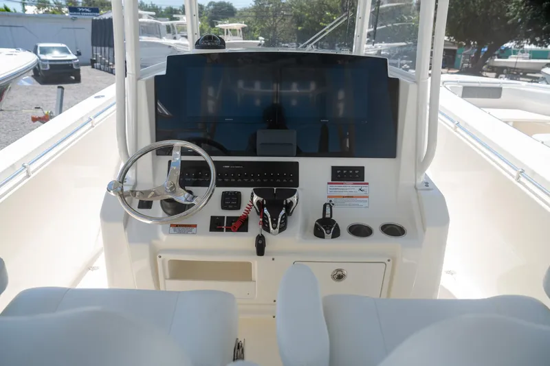 Slide: The Image of 2024 Cobia 320 CC boat dashboard with steering wheel and controls. - 8