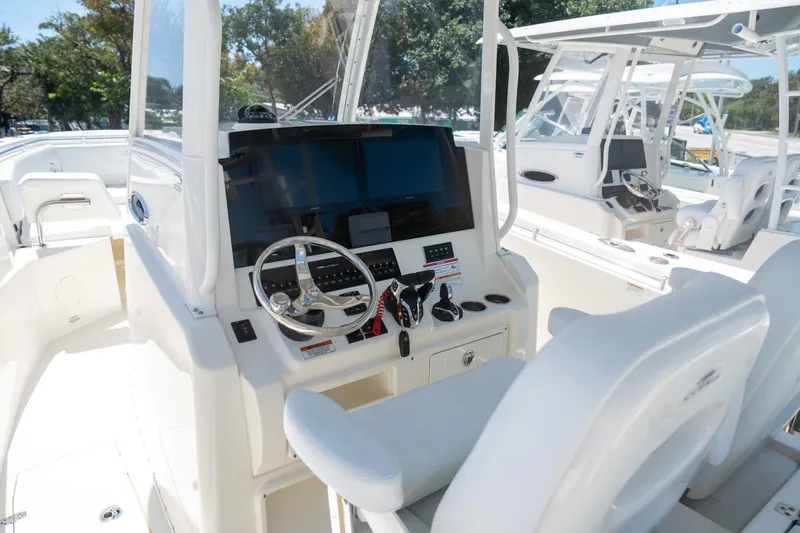 Slide: The Image of 2024 Cobia 320 CC boat cockpit with modern steering and controls. - 9