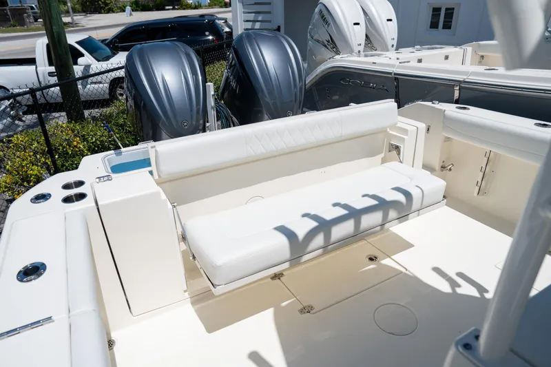 Slide: The Image of 2024 Cobia 320 CC boat with dual outboard engines and white seating. - 27