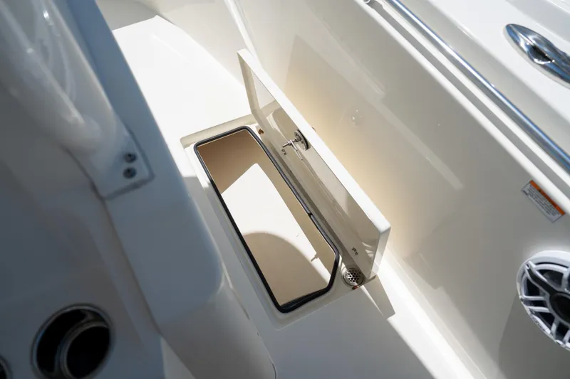 Slide: The Image of 2024 Cobia 320 CC boat storage compartment with open hatch and sleek design. - 34
