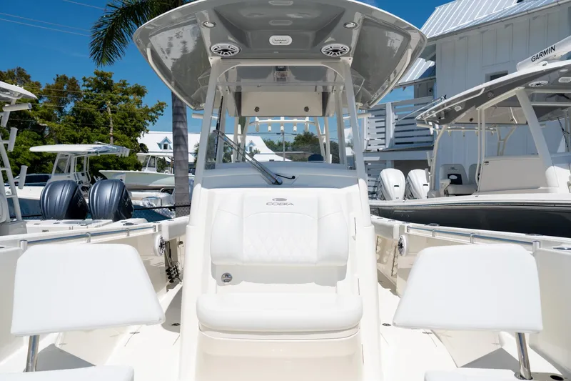 Slide: The Image of 2024 Cobia 320 CC boat interior with seating and helm, displayed outdoors. - 46