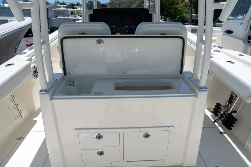Slide: The Image of 2024 Cobia 320 CC boat interior with open storage compartment and seating. - 21