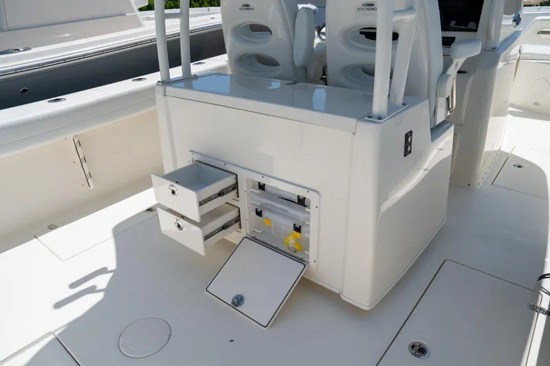 Slide: The Image of 2024 Cobia 320 CC boat interior with open storage compartments and seating. - 23