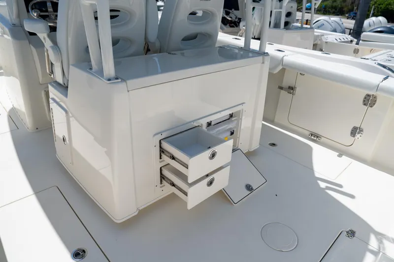 Slide: The Image of 2024 Cobia 320 CC boat interior with open storage drawers and seating. - 24