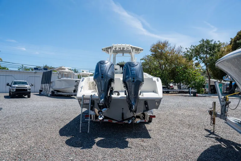 Slide: The Image of 2024 Cobia 320 CC boat with dual outboard engines in a marina setting. - 7