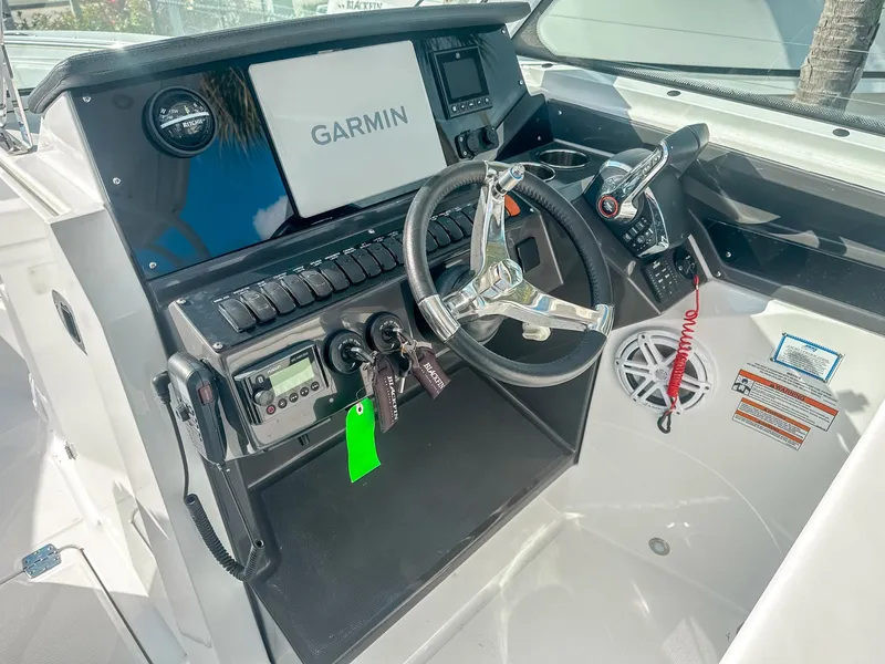 Slide: The Image of 2024 Blackfin 272DC boat dashboard with Garmin navigation system and steering wheel. - 16