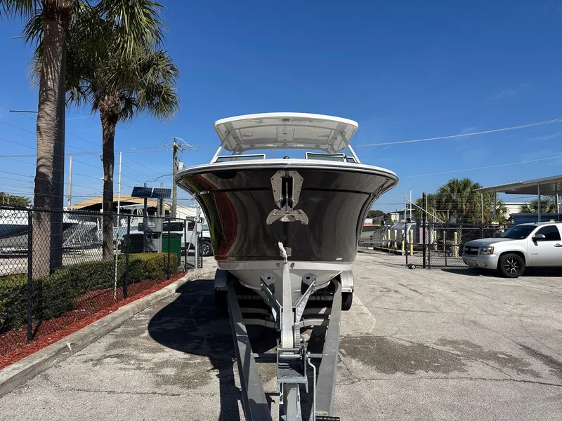 Slide: The Image of 2024 Blackfin 272DC boat on trailer, parked outdoors under clear blue sky. - 3