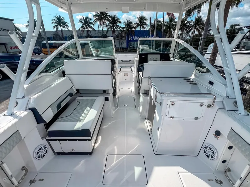 Slide: The Image of 2024 Blackfin 272DC boat interior with seating and console, palm trees in background. - 4
