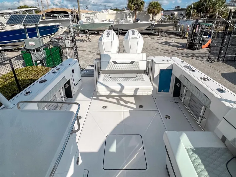 Slide: The Image of 2024 Blackfin 272DC boat interior with seating and storage, docked outdoors. - 12