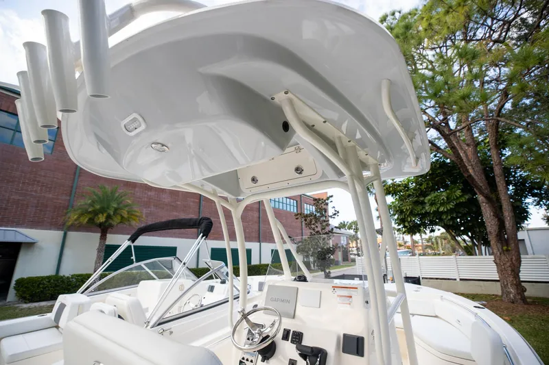 Slide: The Image of 2024 Cobia 220 CC boat interior with steering wheel and T-top structure. - 19