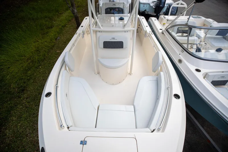 Slide: The Image of 2024 Cobia 220 CC boat interior with white seating and sleek design. - 22