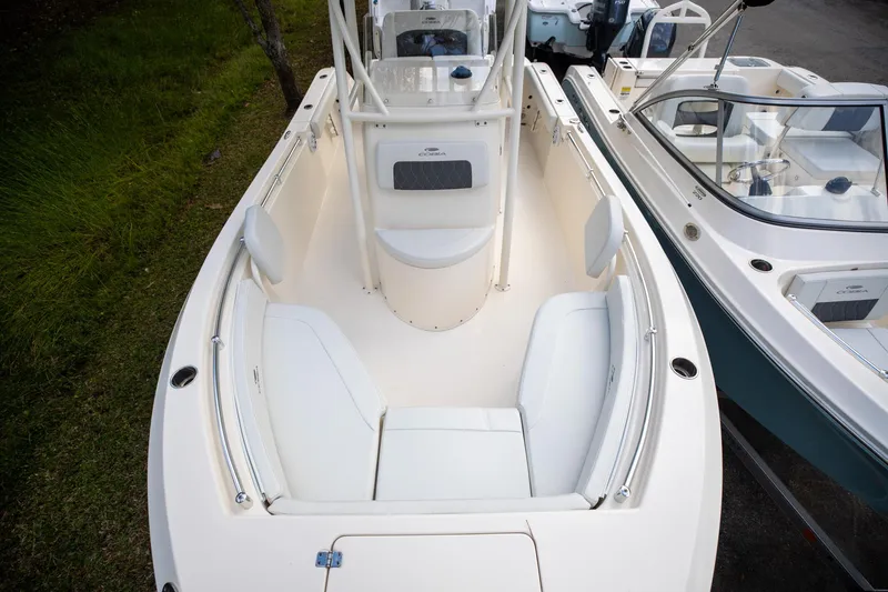 Slide: The Image of 2024 Cobia 220 CC boat interior with white seating and sleek design. - 23