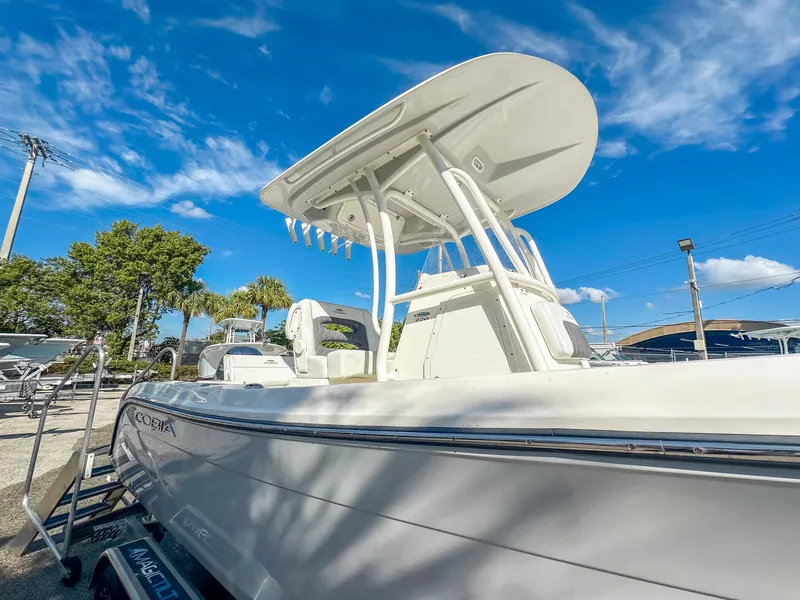 Slide: The Image of 2024 Cobia 220 CC boat with T-top under clear blue sky. - 7