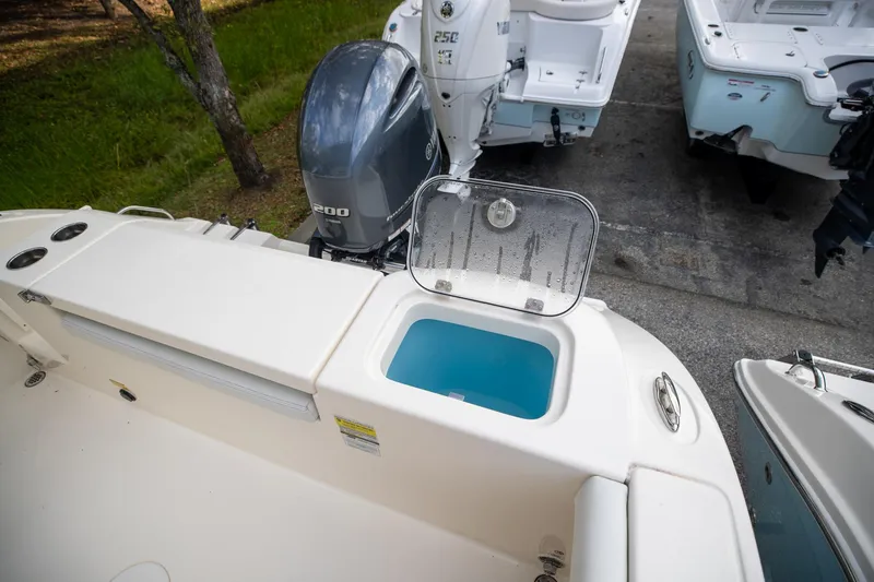 Slide: The Image of 2024 Cobia 220 CC boat with open livewell and Yamaha outboard motor. - 9
